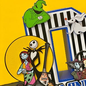 Puede incluir: Una creaci&oacute;n de papel 3D con los personajes de la pel&iacute;cula Pesadilla antes de Navidad. Los personajes incluyen a Jack Skellington, Sally, Oogie Boogie y Zero. La creaci&oacute;n est&aacute; decorada con rayas blancas y negras y la palabra "DOMIN" est&aacute; escrita en letras azules.