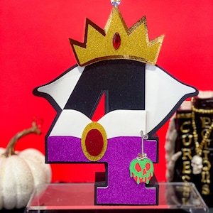 May include: Purple and black number four with a white and gold crown on top. The number has a red circle and a green apple with a skull on it.