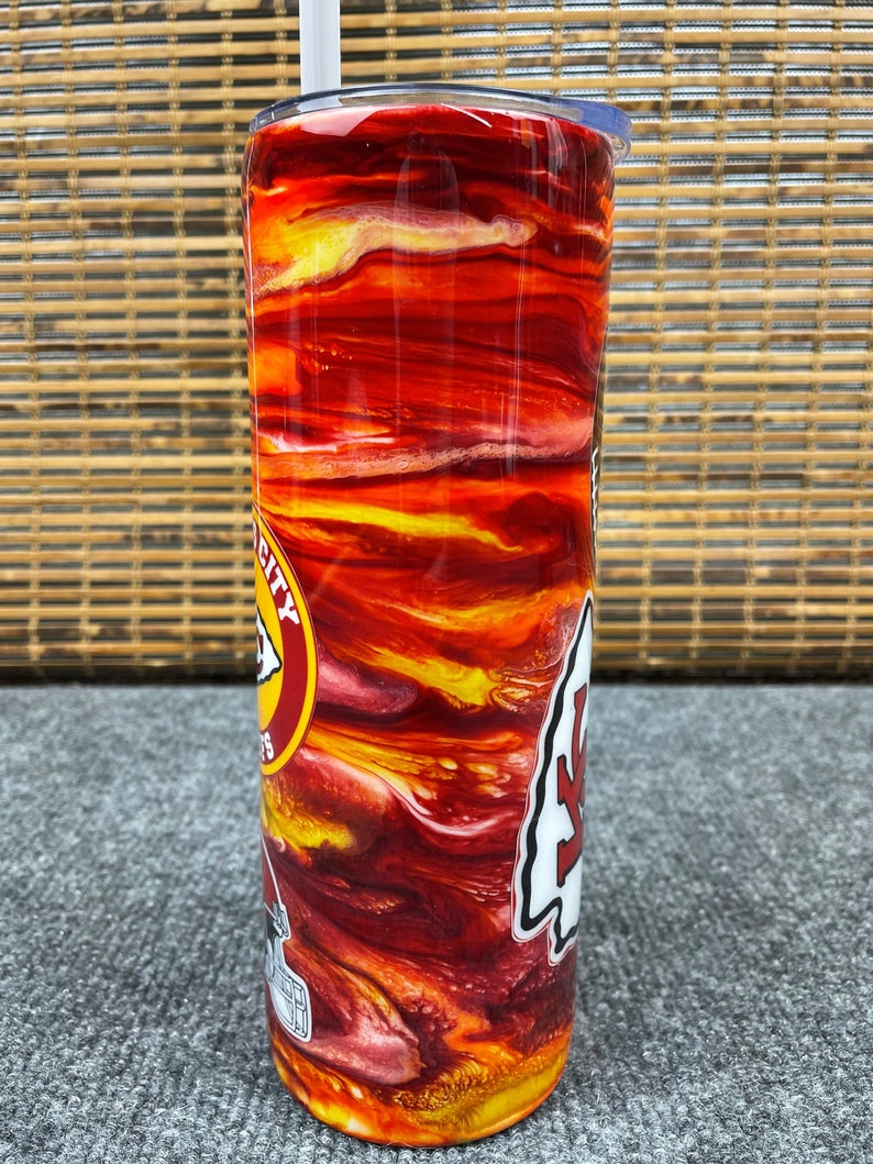 May include: A red, yellow and white stainless steel tumbler with a Chiefs logo and the words "University of Kansas" on it.