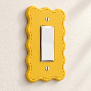 May include: A bright yellow light switch wall plate with a wavy, scalloped edge design. The rectangular plate features a central white rocker switch and is secured to the wall with two visible silver-colored metal screws at the top and bottom.