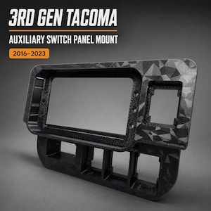 May include: A black 3D GEN TACOMA AUXILIARY SWITCH PANEL MOUNT 2016-2023 with a geometric triangular pattern. The mount features a large rectangular opening, a smaller square opening, and four lower rectangular slots for switch installation.