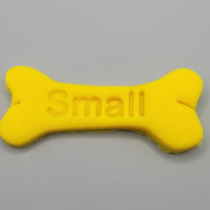 May include: A yellow bone-shaped dog treat with the word "Small" embossed on it.