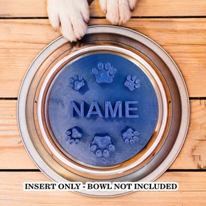 May include: Blue dog bowl insert with paw prints and the word "NAME" in raised letters.  Insert only - bowl not included.