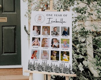 Op de afbeelding: Een wit posterbord met een zwart-wit bosontwerp aan de onderkant. Het posterbord heeft een titel die luidt "One Year of Isabella". Er zijn 12 foto's van een babymeisje, één voor elke maand van het jaar.