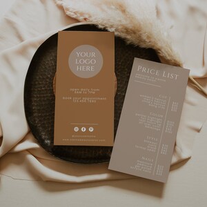 May include: Two business cards on a dark metal tray. One card is tan with a logo placeholder, contact info, and social media icons. The other is taupe with a price list for a beauty salon.