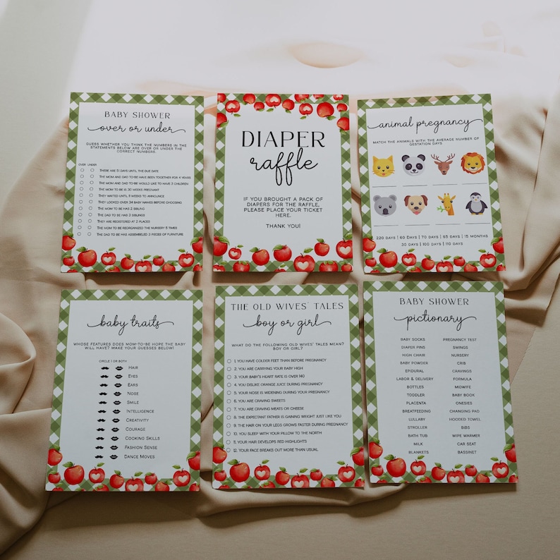 May include: A set of printable baby shower game cards with a red and green gingham pattern and apple illustrations. The games include "Over or Under", "Diaper Raffle", "Animal Pregnancy", "Baby Traits", "The Old Wives Tales: Boy or Girl", and "Baby Shower Pictionary".