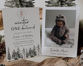 May include: Two rectangular birthday invitation cards featuring a winter theme. The left card displays the text 'winter ONEderland', 'Isabella's 1st Birthday', and event details. The right card features a photo of a baby in a brown hooded jumpsuit.
