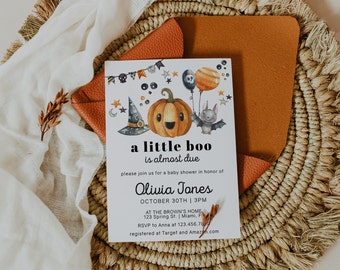 May include: A Halloween-themed baby shower invitation with a pumpkin wearing a witch's hat and a bat. The text reads "a little boo is almost due" and includes the name "Olivia Jones", the date "October 30th", and the time "3pm".
