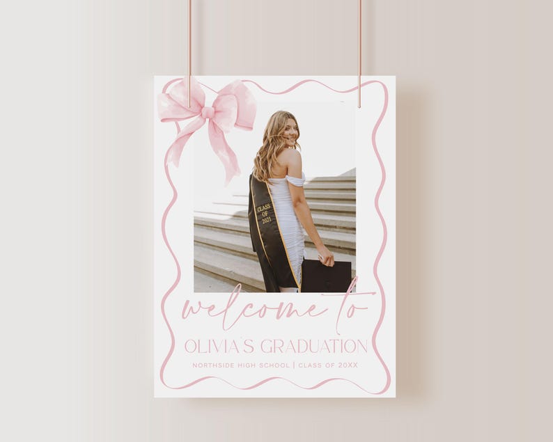 May include: A pink and white graduation welcome sign with a photo of a graduate in a cap and gown. The sign says "Welcome to Olivia's Graduation" and "Northside High School | Class of 20XX".