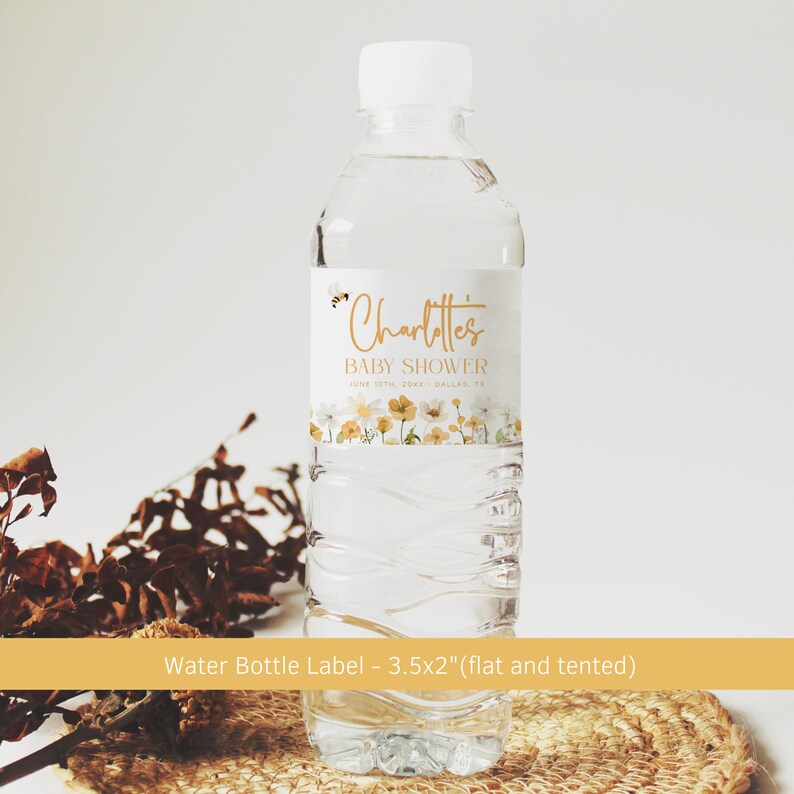 May include: Water bottle label with a floral design and a bee. The label says "Charlotte's Baby Shower" with the date and location. The label is 3.5 inches by 2 inches and is designed to be flat or tented.