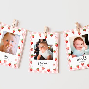 May include: Three pink and white photo cards with a strawberry pattern. Each card has a photo of a baby and the text "six months", "seven months", and "eight months".