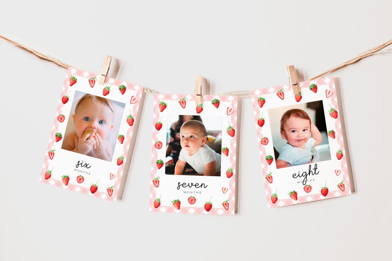 May include: Three pink and white photo cards with a strawberry pattern. Each card has a photo of a baby and the text "six months", "seven months", and "eight months".