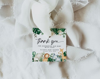May include: Thank you card with a jungle animal theme. The card features a green background with illustrations of a giraffe, elephant, lion, rhino, and a leafy branch. The text on the card reads "Thank you for showering our baby with love! Oliver's Baby Shower August 10th, 20XX".