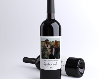 May include: A wine bottle label with a photo of two women smiling and the text "GRACE, WILL YOU BE MY BRIDESMAID?" with a heart.