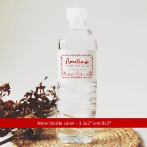 May include: A clear plastic water bottle with a white cap and a label that reads "Amelia's BABY SHOWER" in red script. The label has a decorative border and small illustrations. The text "April 10th, 2014 | Miami, FL" is also on the label.
