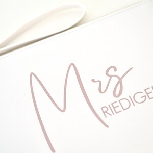 Pode incluir: Bolsa de m&atilde;o branca com uma inscri&ccedil;&atilde;o rosa em cursivo que diz "Mrs. Riediger".