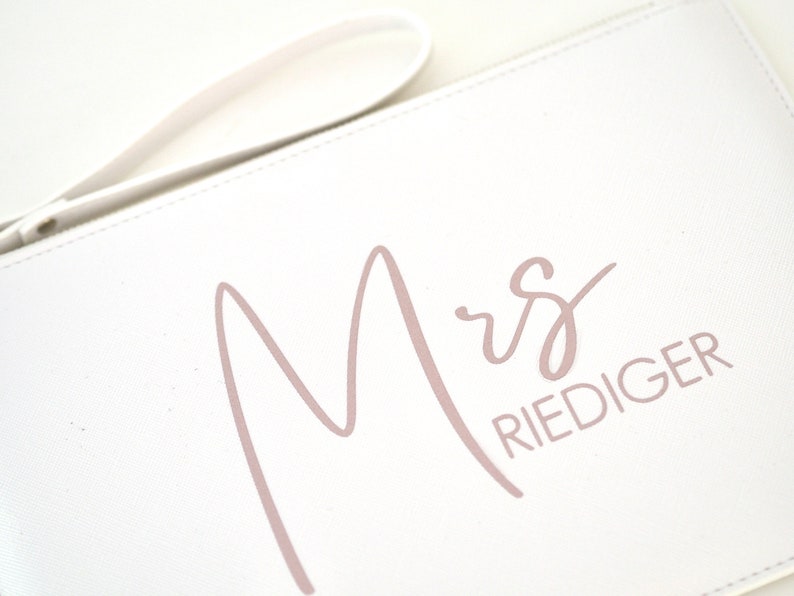 Pode incluir: Bolsa de m&atilde;o branca com uma inscri&ccedil;&atilde;o rosa em cursivo que diz "Mrs. Riediger".