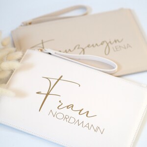 Pode incluir: Duas bolsas de m&atilde;o brancas com letras douradas. Uma bolsa diz "Frau Nordmann" e a outra diz "Trauzeugin Lena".