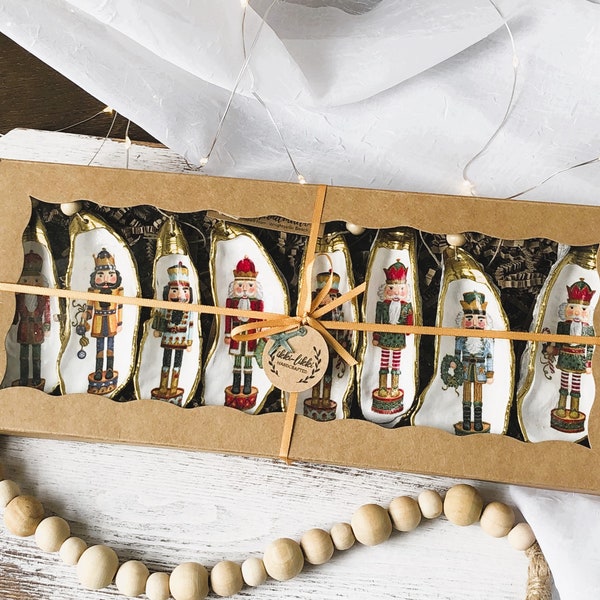 Decoupaged oyster shell Christmas ornaments decorated with nutcrackers. Great gift for Nutcracker collectors. Giftbox contains 8 ornaments.