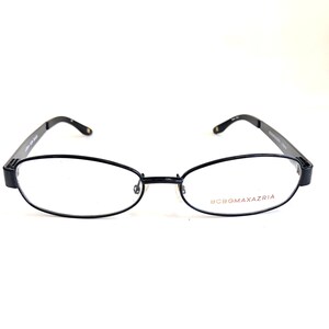 May include: Black oval-shaped eyeglasses with a thin metal frame. The brand name "BCBGMAXAZRIA" is printed in red on the right lens.