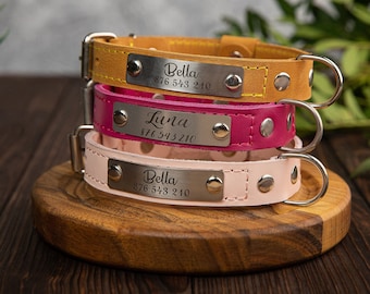 May include: Three leather dog collars with personalized metal tags. The top collar is yellow, the middle collar is pink, and the bottom collar is light pink. Each tag has a name and phone number engraved on it. The tags read "Bella 876 543 210", "Luna 876 543 210", and "Bella 876 543 210".