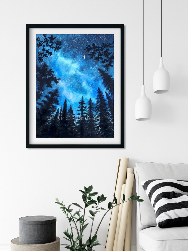 May include: A framed watercolor painting of a starry night sky, with silhouetted pine trees in the foreground. The artwork features a vibrant blue and white galaxy, a shooting star, and the text "AidaTurkkyArt". The frame is black.