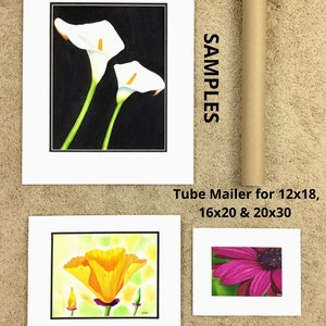 May include: An assortment of floral art prints, including a watercolor of two white calla lilies against a black background, a vibrant orange poppy, and a close-up of a pink flower. The prints are matted and labeled with sizes.