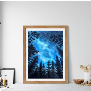 May include: Watercolor painting of a starry night sky with a bright blue and white galaxy. Silhouetted trees frame the bottom of the artwork. The painting is in a wooden frame. The artist's signature is visible.