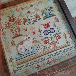 以下が含まれることがあります： 猫、花、鳥、テキストが描かれた額入りのアンティーククロスステッチのサンプル。 サンプルは1836年製で、「Frances Haleys Work」のテキストが含まれています。 寸法は17.8 cm x 17.7 cmです。