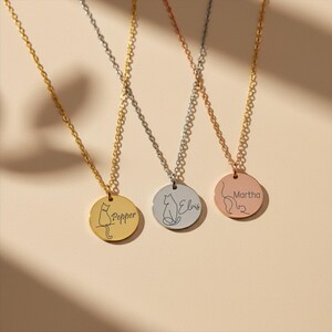 May include: Three circular pendant necklaces in gold, silver, and rose gold tones. Each pendant features a minimalist line-art cat silhouette and a custom name engraving: Pepper on the gold, Elvis on the silver, and Martha on the rose gold.