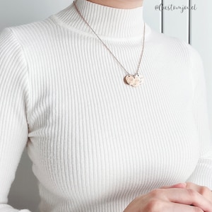 May include: A rose gold-toned necklace featuring a delicate chain and three small, circular, engraved pendants. The necklace is worn over a white, long-sleeved, ribbed mock-neck sweater. The text @customjouel is visible in the upper right corner.