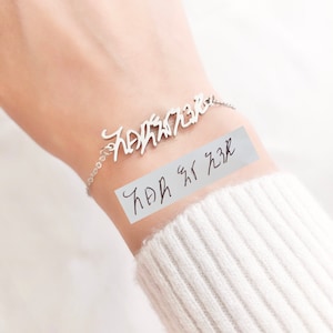 Peut inclure: Un bracelet en argent avec un nom personnalisé écrit en cursive. Le nom est "Hannah Rose".