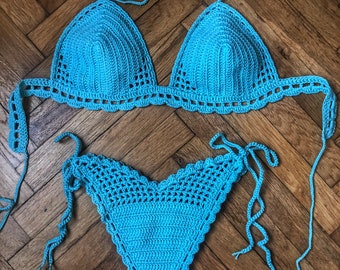 May include: A turquoise blue crochet bikini top and bottom with adjustable straps. The bikini is made of a soft, lightweight material and is perfect for a day at the beach.