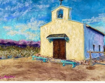 May include: An oil painting of a small, cream-colored mission church with a bell tower and dark wooden doors. Two turquoise benches sit in front of the building on a dirt ground, set against a vibrant blue sky with purple hills in the distance.