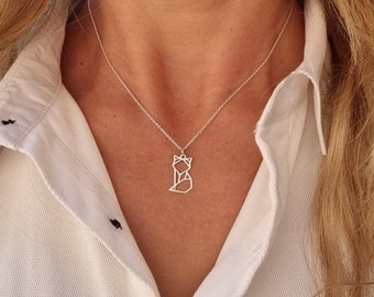Puede incluir: Un collar de plata con un colgante de zorro origami geométrico.