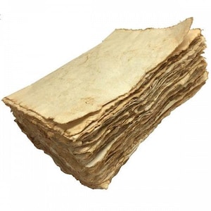 Könnte beinhalten: Ein Stapel handgemachtes, cremefarbenes Papier mit einer rauen, strukturierten Oberfläche. Das Papier ist leicht bräunlich und hat einen rustikalen, Vintage-Look.