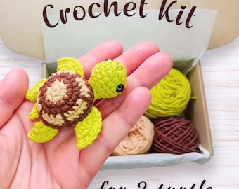 Puede incluir: Un kit de ganchillo para 2 tortugas que incluye una pequeña tortuga de hilo hecha a mano en color verde lima y marrón con ojos de seguridad negros. El kit contiene tres ovillos de hilo en verde lima, beige y marrón oscuro, presentados en una caja de cartón con el texto Crochet Kit for 2 turtle.
