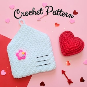 May include: A light blue crocheted envelope with a pink flower embellishment and black lines, next to a red crocheted heart. The words "Crochet Pattern" are written above the envelope. Decorative hearts and arrows are scattered around.