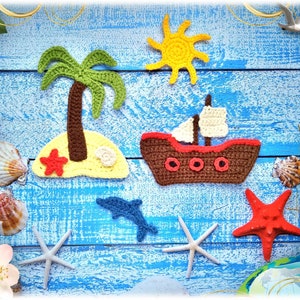 Op de afbeelding: Gehaakte vilt applique set met een palmboom op een eiland, een zeilboot, een rode zeester, een zon en een dolfijn. De appliques zijn op een blauwe houten achtergrond.