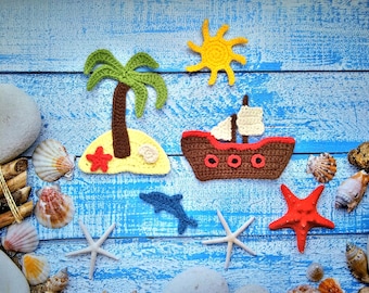 Puede incluir: Decoraciones de ganchillo sobre un fondo de madera azul. Las decoraciones incluyen una palmera, un barco, un sol y estrellas de mar. También hay conchas y piedras en el fondo.