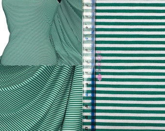 Puede incluir: Tela de rayas verdes y blancas con una cinta métrica blanca. La tela es suave y elástica, perfecta para proyectos de costura.