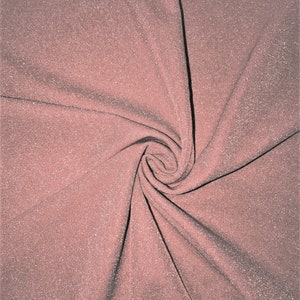 Op de afbeelding: Een close-up van een roze glinsterende stof met een swirl-patroon.