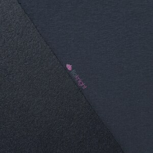 May include: Close-up of two sections of fabric in shades of gray. One section has a textured, fleece-like appearance, while the other is smooth. The brand name "fioknight" is printed in pink on the smooth fabric.