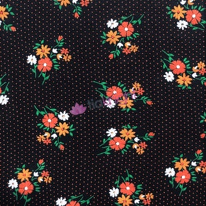 May include: Black fabric with a white polka dot pattern and a repeating floral design featuring orange, white, and green flowers.