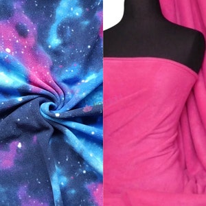 May include: Two pieces of fleece fabric. One piece is a blue and pink galaxy print. The other piece is solid pink.