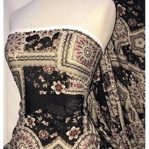 Peut inclure: Tissu noir transparent avec un motif paisley et floral. Le tissu présente des détails complexes et une esthétique vintage.