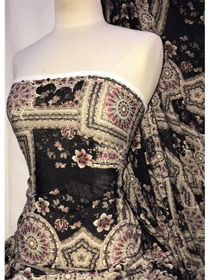 May include: Black sheer fabric with a paisley and floral pattern. The fabric features intricate details and a vintage aesthetic.