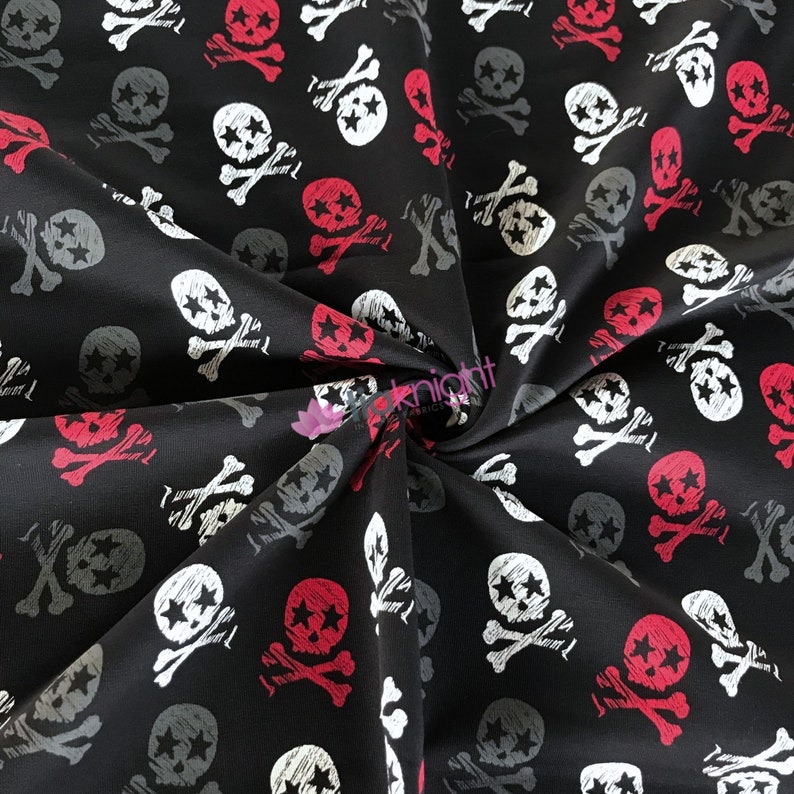 May include: Black fabric with a repeating pattern of white and red skull and crossbones. The skulls have stars in their eyes.