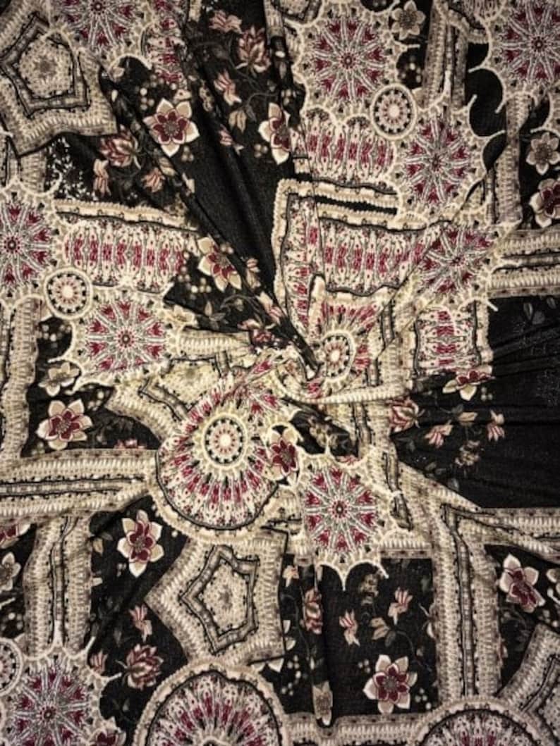 May include: Black fabric with a repeating pattern of intricate floral and geometric designs in shades of cream, burgundy, and gold.