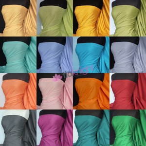 May include: A collection of fabric samples in a range of colours, draped over mannequins. The colours include shades of yellow, green, blue, orange, pink, and red. The fabric appears to be a lightweight material, suitable for clothing or craft projects.